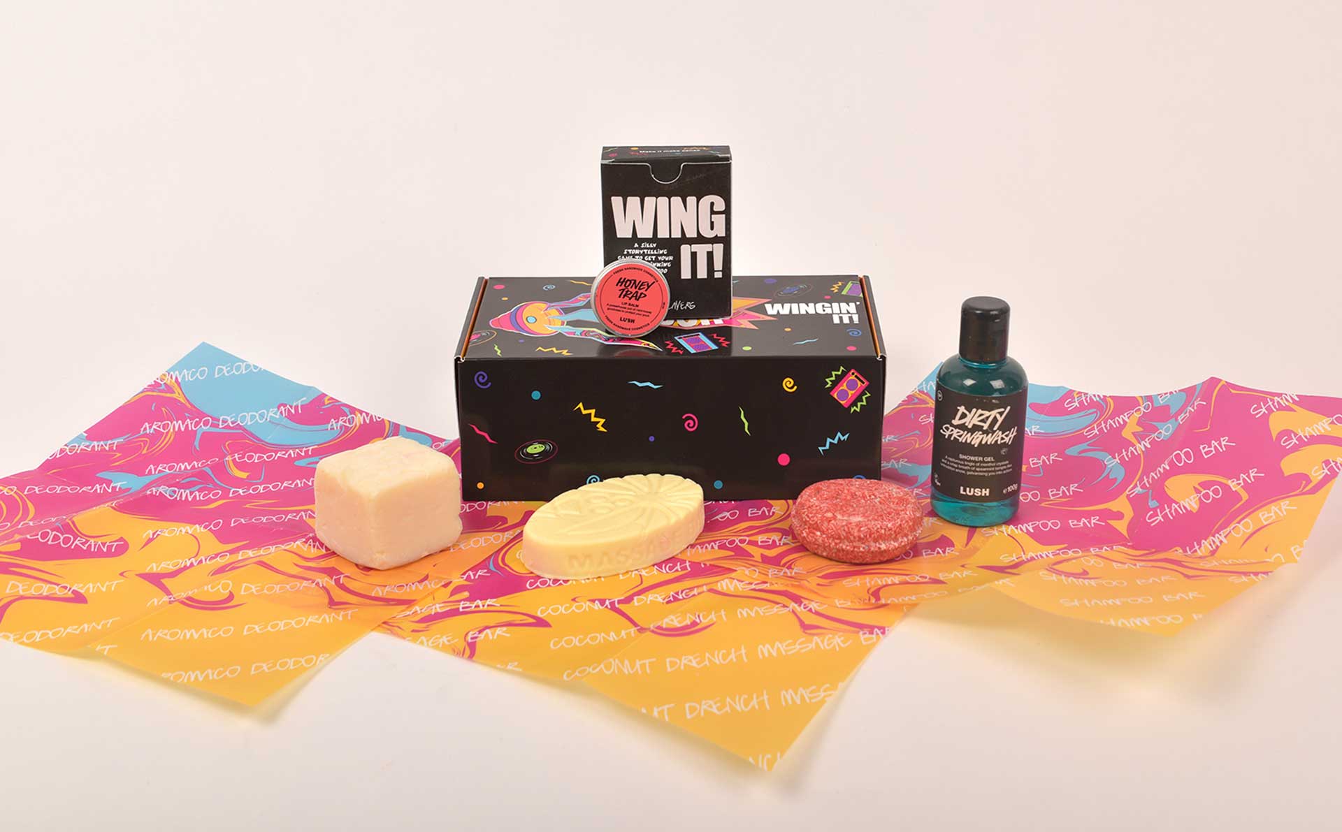 Lush kit: Dirty Springwash Shower Gel, Honey Trap lip scrub, Aromaco Deodorant, Coconut Drench massage bar, shampoo bar, and Wing It card game.